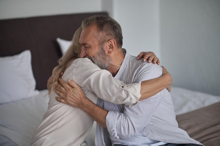 Loving husband embracing his female spouse after their reconciliationの写真素材