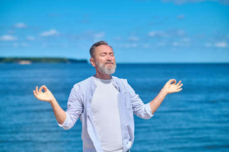 Man meditating in pose of gyana mudraの写真素材
