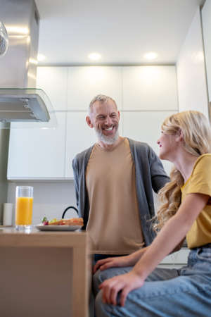 A father and a daughter in the kitchen having breakfastの写真素材