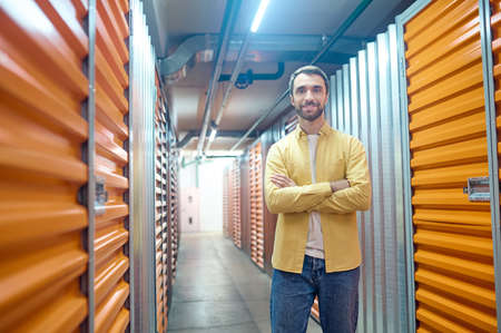 Smiling man with folded hands in basementの写真素材