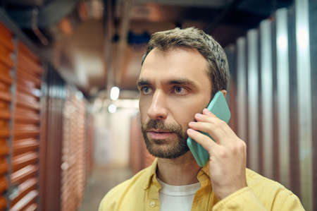 Serious attentive man talking on smartphone