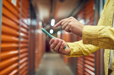 Hand with smartphone and finger above screenの写真素材