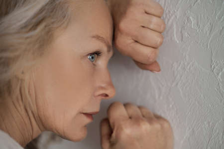 Beautiful serious mature woman pondering over somethingの写真素材