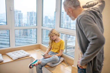 A gray-haired man having a hard talk with his teenage daughterの写真素材