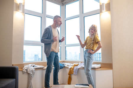 A gray-haired man having an argument with his teenage daughter