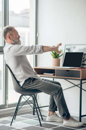 A mature self-employed man working at home and looking tired