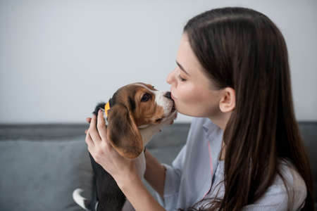 Pet owner with a cute little puppy at home