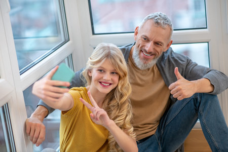 A gray-haired mature man and his daughter feeling good togetherの写真素材