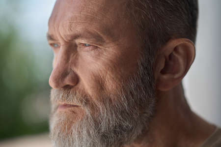 Serious gray-headed man staring into the distance