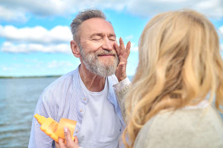 Satisfied man with closed eyes and woman touching hand