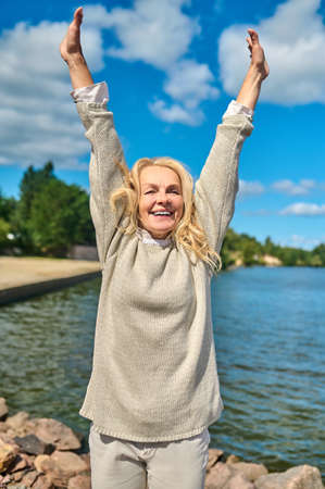 Smiling woman with hands raised upの写真素材