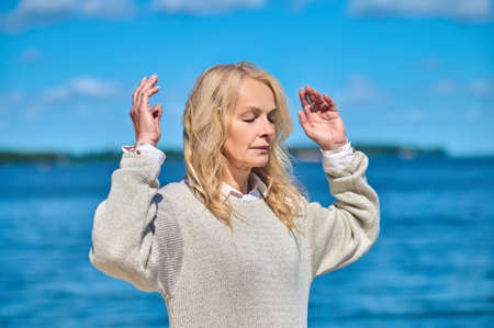 Woman relaxed with raised arms outdoors