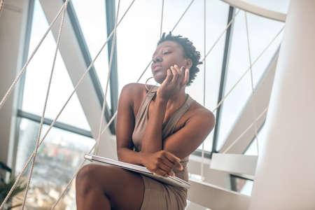 Dark-skinned young woman on the stairsの写真素材