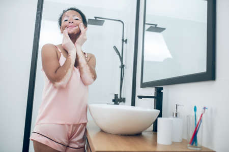 A pretty young woman cleansing her face with a spongeの写真素材