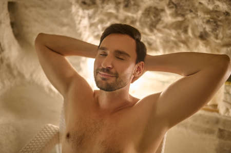 A dark-haired man looking relaxed and enjoyed while spending time in a spa centerの写真素材
