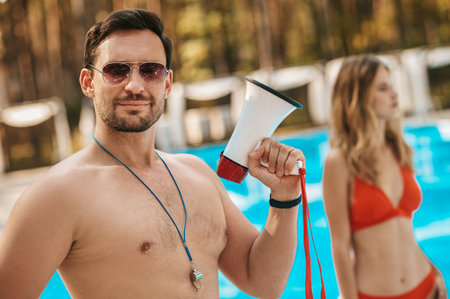 Two pool lifeguards walking near the public pool and talkingの写真素材