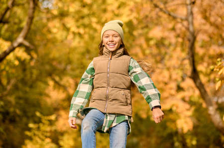 A girl in warm clothes playing in the parkの写真素材