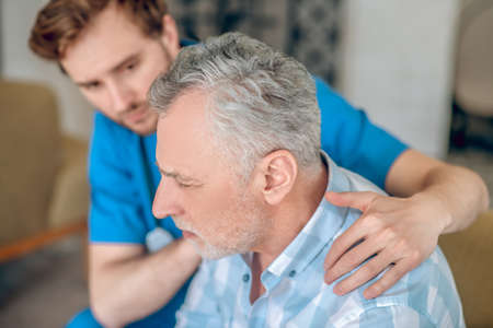 Attentive healthcare professional taking care of his patientの写真素材