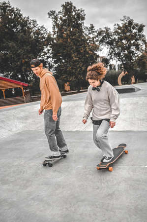Girl and guy skateboarding in park exercisingの写真素材