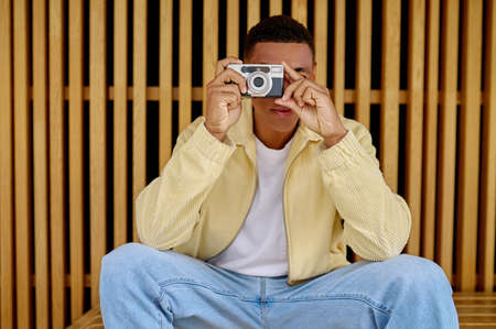 Male photographer sitting and holding camera in hands