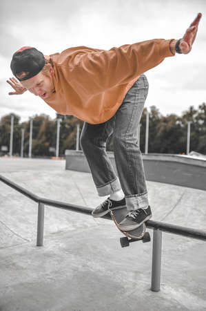 Guy on skateboard flying over railing in skatepark
