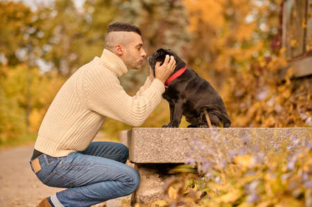 A man stroking his dog and looking happyの写真素材