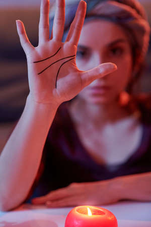 Serious chiromantist showing palmar creases for the cameraの写真素材