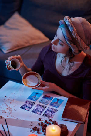 Focused fortune-teller starting the coffee reading procedureの写真素材