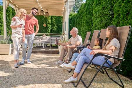 A family gathered in the back yard and looking happy