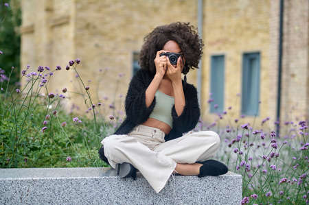 Dark-haired female photographer making photos