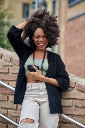 Curly-haired young woman posing and looking happy