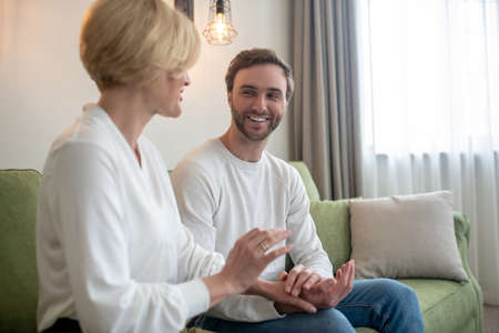 Son and mom sitting next to each other and talkingの写真素材