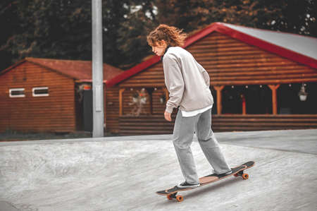Profile of girl on skateboard descending from hillの写真素材