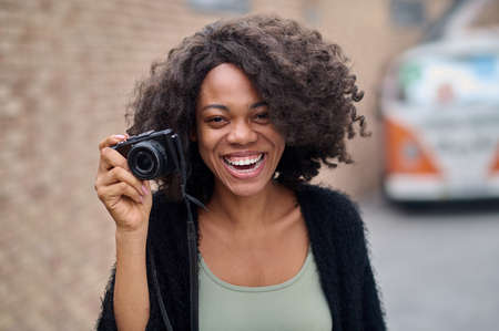 Pretty young female photographer smiling positivelyの写真素材