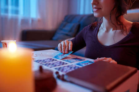 Dark-haired Caucasian soothsayer laying out Tarot cards