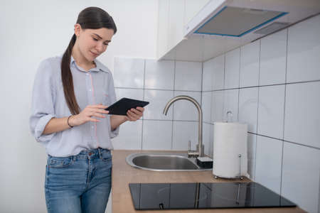 Female activating the cooktop with a tabletの写真素材