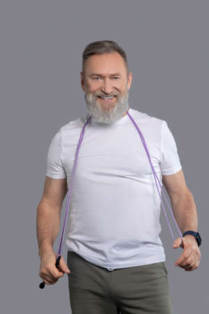 A smiling positive man with a jump rope in hands