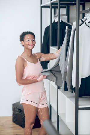 A pretty young female choosing clothes from her wardrobeの写真素材