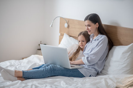 Mother and her daughter staring at the laptopの写真素材