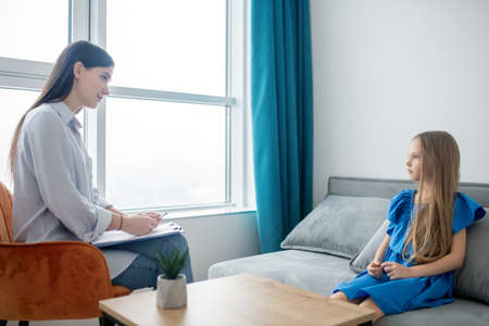 Young mother teaching her daughter at homeの写真素材
