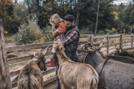 Blonde cute girl standing near the cattle-penの写真素材