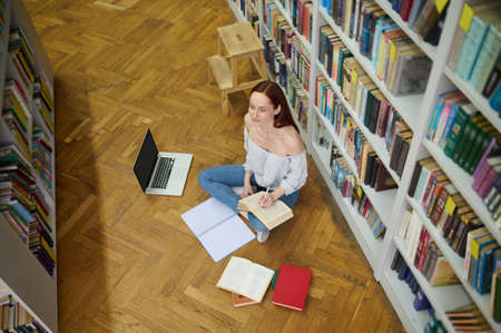 Top view of woman writing while sitting on floor