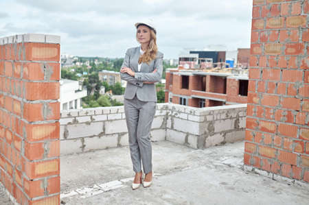 Woman standing on building under construction looking asideの写真素材