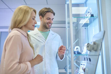 Man showing hearing aids to woman