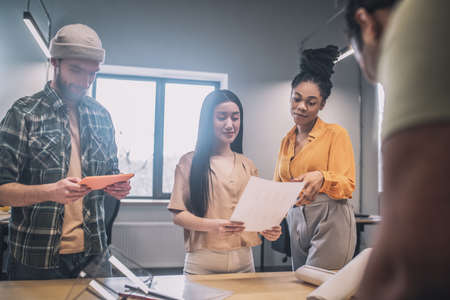 Group of young people near table in office