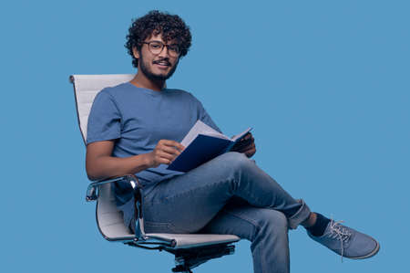 Pleased cute guy with a diary looking ahead