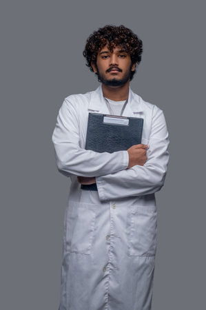 Young doctor with medical documents looking ahead