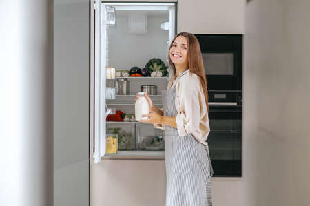 Young woman taking food from the fridgeの写真素材