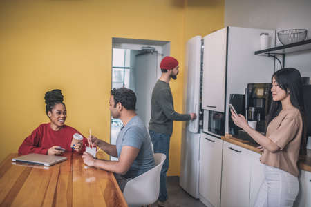 Guys and girls in kitchen of modern officeの写真素材