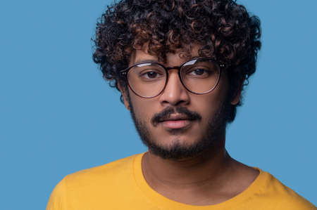 Serene man in trendy spectacles staring ahead